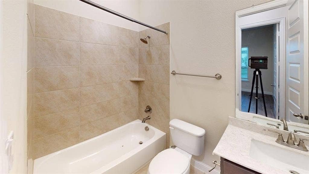 3314 Willena Road, Melissa, TX 75454 Bathtub with tiled surround, wall-mounted shower head, and built-in shelf