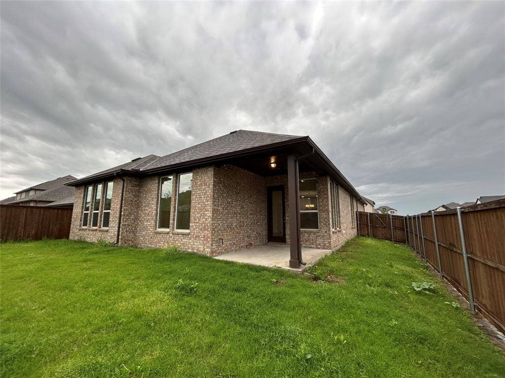 3314 Willena Road, Melissa, TX 75454 Modern brick residence with expansive covered patio, large multi-pane windows, and manicured lawn with mature landscaping and privacy fencing