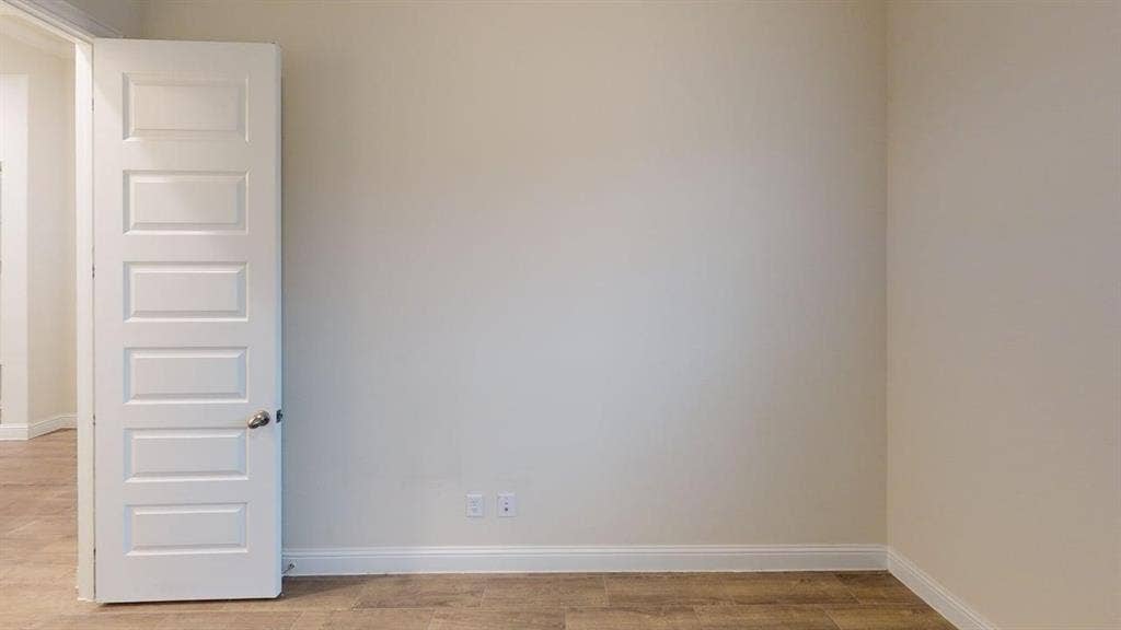 3314 Willena Road, Melissa, TX 75454 Wood-finish flooring, light-colored wall paint, white trim, and a five-panel interior door