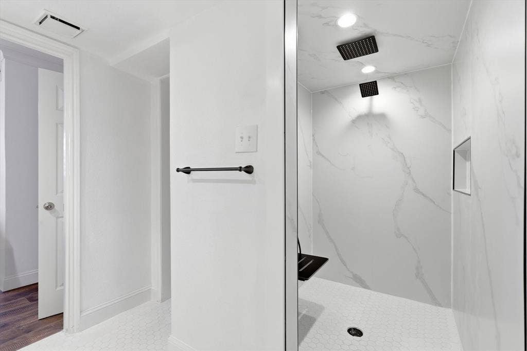 10207 Regal Oaks Drive, #109, Dallas, TX 75230 Updated oversized shower with a clean, modern finish and contrasting black fixtures.