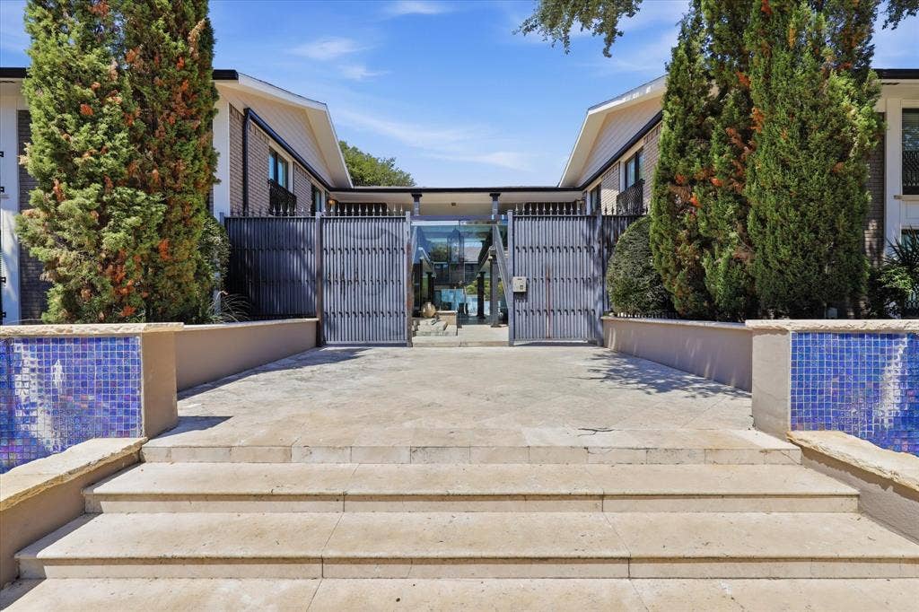 10207 Regal Oaks Drive, #109, Dallas, TX 75230 Gated entrance to the community framed by mature landscaping.