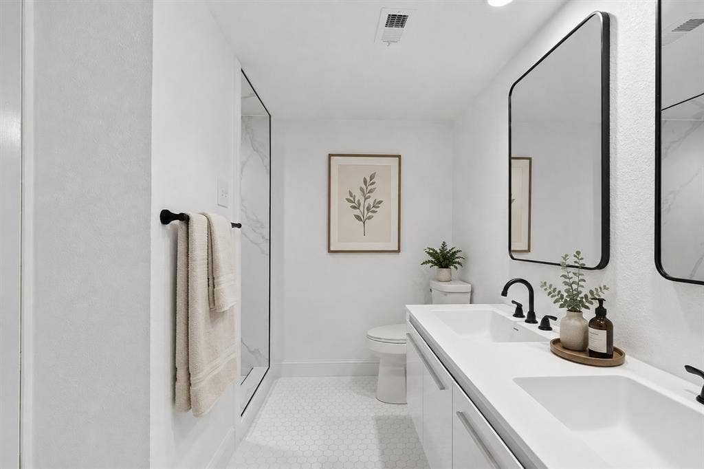 10207 Regal Oaks Drive, #109, Dallas, TX 75230 Virtually staged remodeled bathroom featuring a double vanity, updated fixtures, contemporary mirrors and a clean, neutral finish.