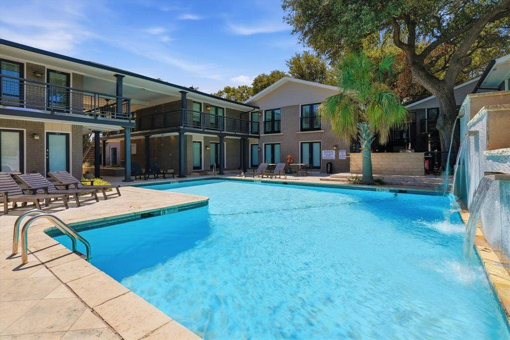 10207 Regal Oaks Drive, #109, Dallas, TX 75230 Additional view of the pool area surrounded by mature landscaping and the residential buildings just steps from your condo.