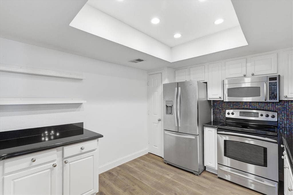 10207 Regal Oaks Drive, #109, Dallas, TX 75230 Another view of the kitchen showcasing the generous cabinetry, stainless steel appliances and functional workspace.