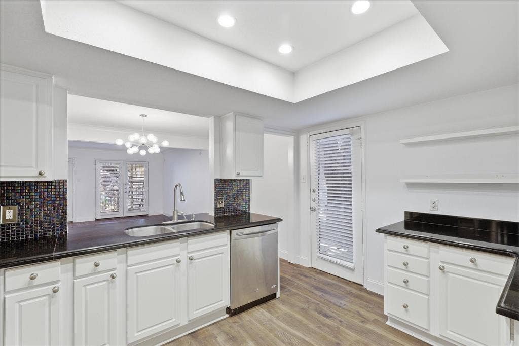 10207 Regal Oaks Drive, #109, Dallas, TX 75230 Kitchen view toward the rear entrance, with abundant cabinetry and counter space.