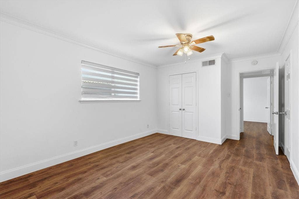 10207 Regal Oaks Drive, #109, Dallas, TX 75230 Spacious primary bedroom with updated flooring, fresh neutral paint and natural light from the window.
