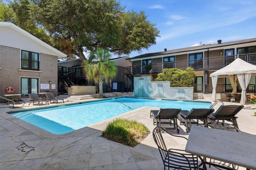 10207 Regal Oaks Drive, #109, Dallas, TX 75230 Another view of the nearby community pool with its tranquil waterfalls and surrounding lounge area.