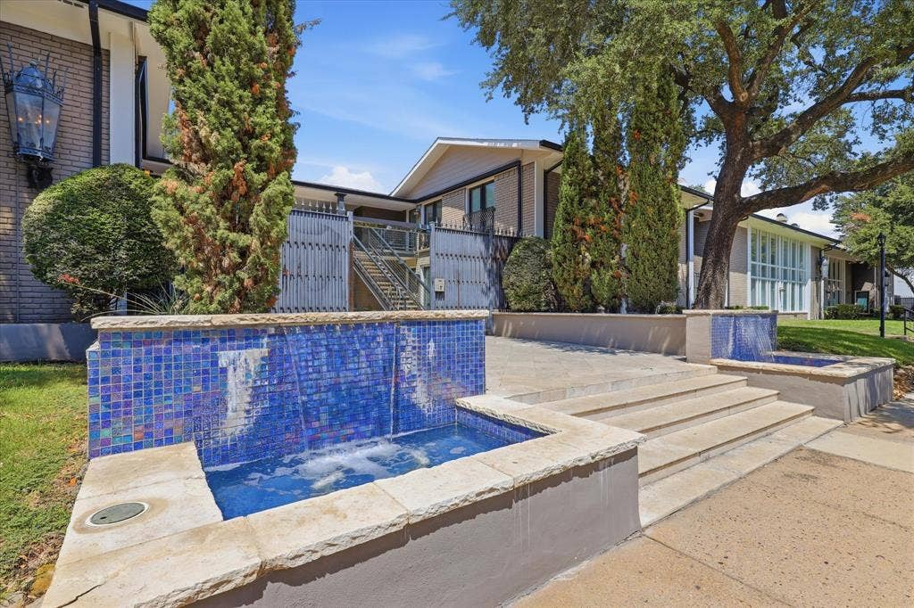 10207 Regal Oaks Drive, #109, Dallas, TX 75230 Community entry area with established landscaping and a welcoming courtyard setting.