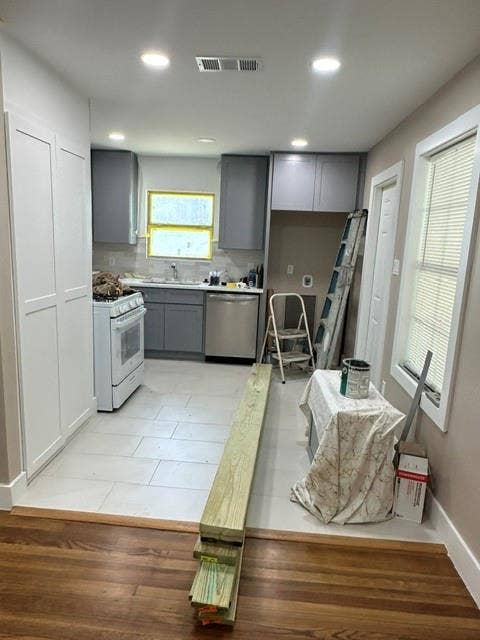 12203 Galva Drive, Dallas, TX 75243 Recessed lighting, wood-finish flooring, white flat-panel cabinetry, gray shaker-style cabinetry, and light-toned tile flooring