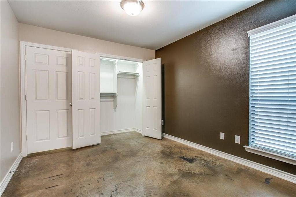 2415 Stutz Drive, #D, Dallas, TX 75235 Expansive flooring, dual closet doors with six-panel design, interior closet shelving, and a prominent window with blinds