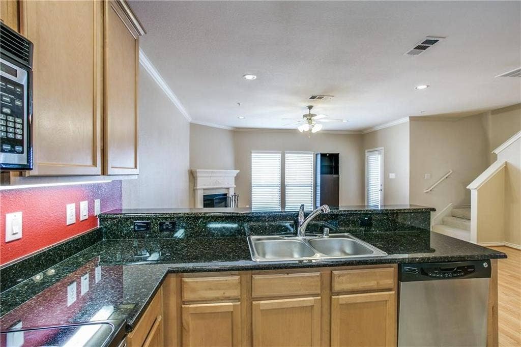 2415 Stutz Drive, #D, Dallas, TX 75235 Kitchen with dark granite countertops, light wood cabinetry, and stainless steel appliances