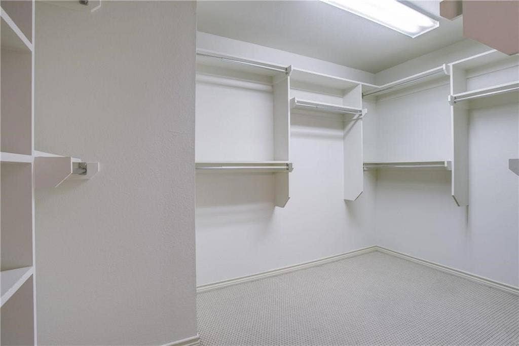 2415 Stutz Drive, #D, Dallas, TX 75235 Built-in shelving units, multiple hanging rods, carpet flooring, and recessed ceiling lighting