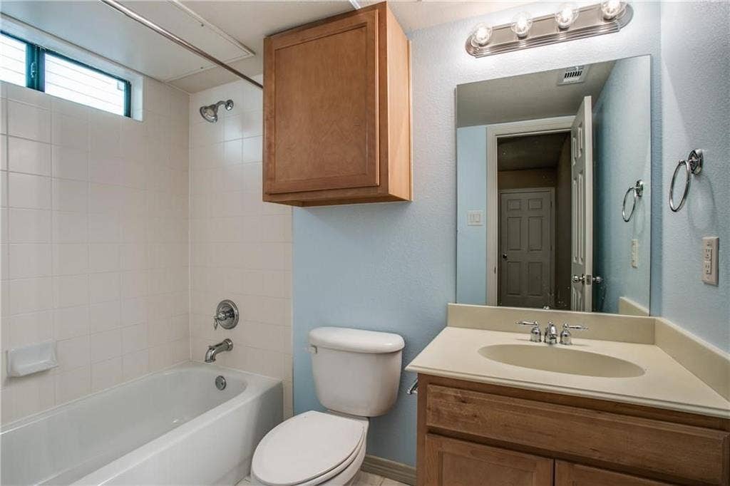 2415 Stutz Drive, #D, Dallas, TX 75235 White tiled bathtub/shower combination with a transom window