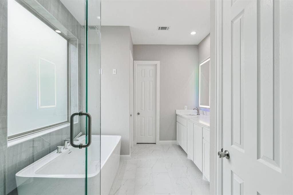 15456 Mountain View Lane, Frisco, TX 75035 Freestanding tub with a glass shower enclosure, double vanity with white cabinetry, and recessed lighting
