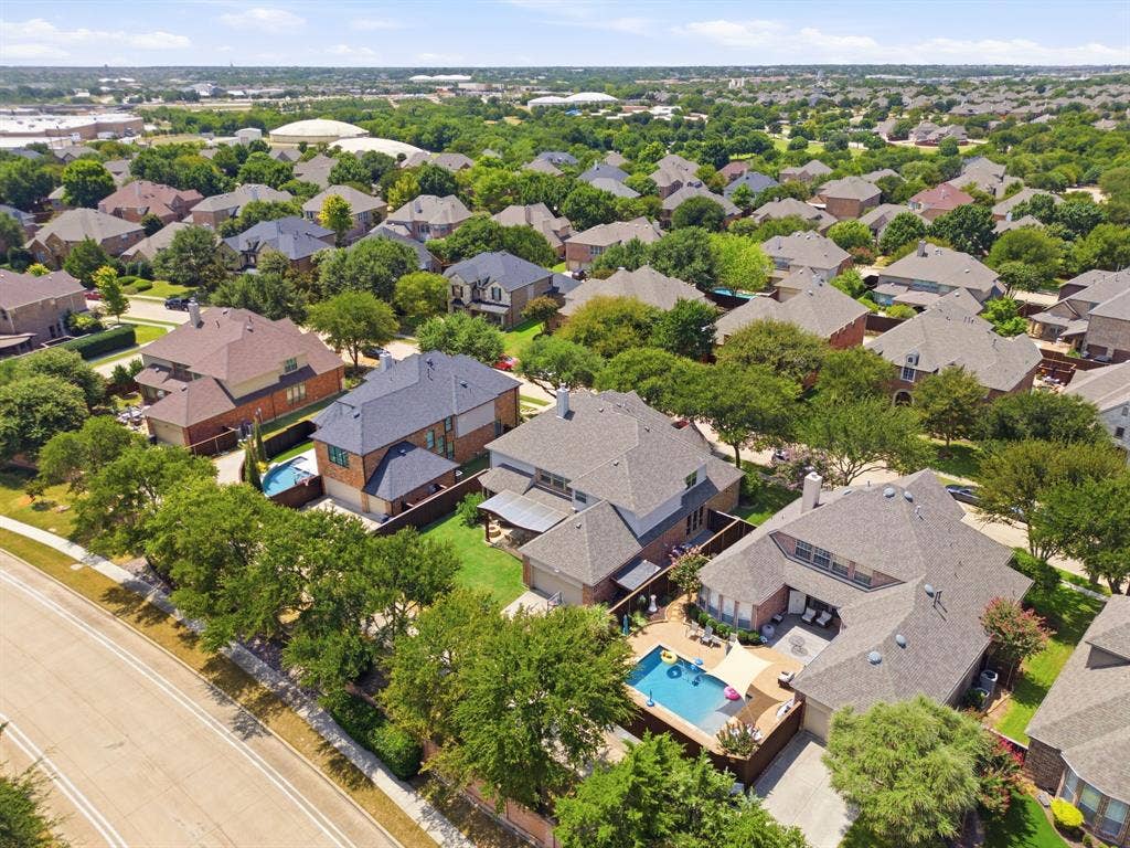 15456 Mountain View Lane, Frisco, TX 75035 Aerial perspective showcasing a residential neighborhood with numerous detached homes, mature tree coverage, and private swimming pools