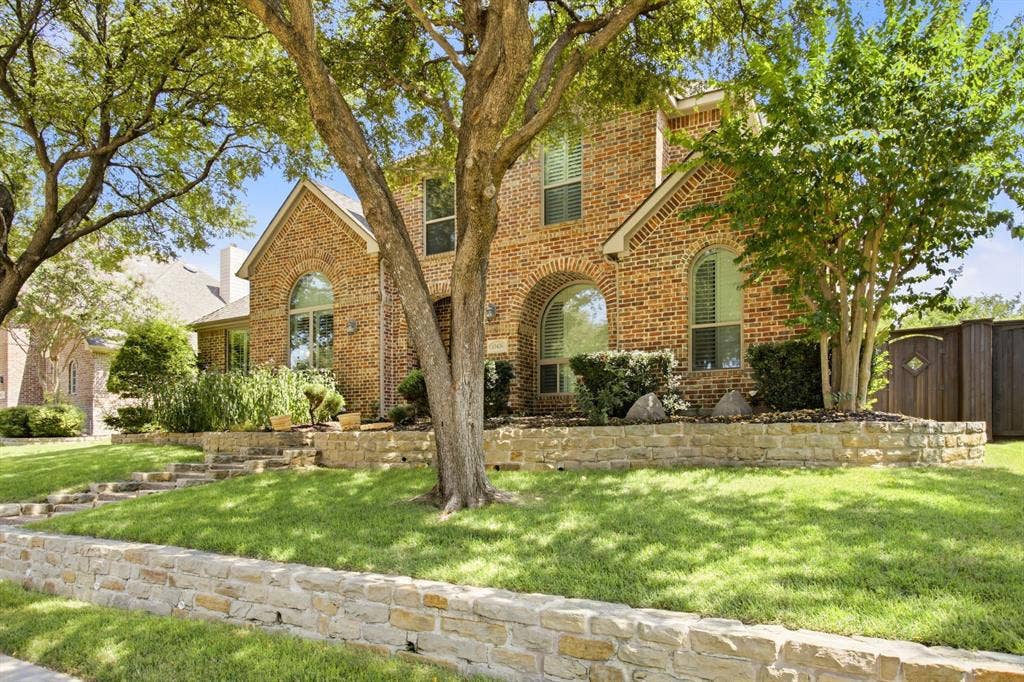 15456 Mountain View Lane, Frisco, TX 75035 Brick exterior with arched windows, multiple gables, stone retaining walls, and mature trees