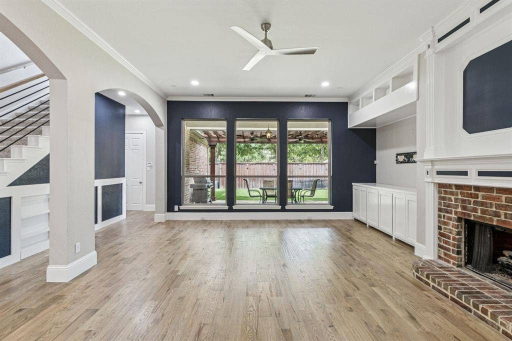 15456 Mountain View Lane, Frisco, TX 75035 Expansive living area with wood-finish flooring, a traditional brick fireplace, and built-in cabinetry