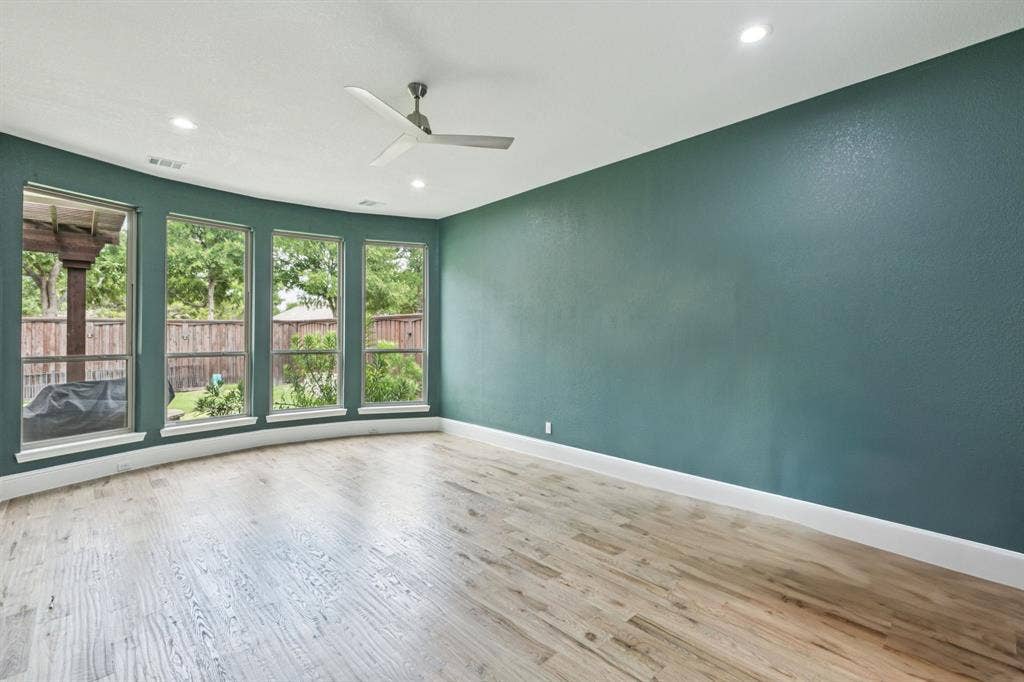 15456 Mountain View Lane, Frisco, TX 75035 Curved wall with four large windows, wood-finish flooring, recessed lighting, and a ceiling fan