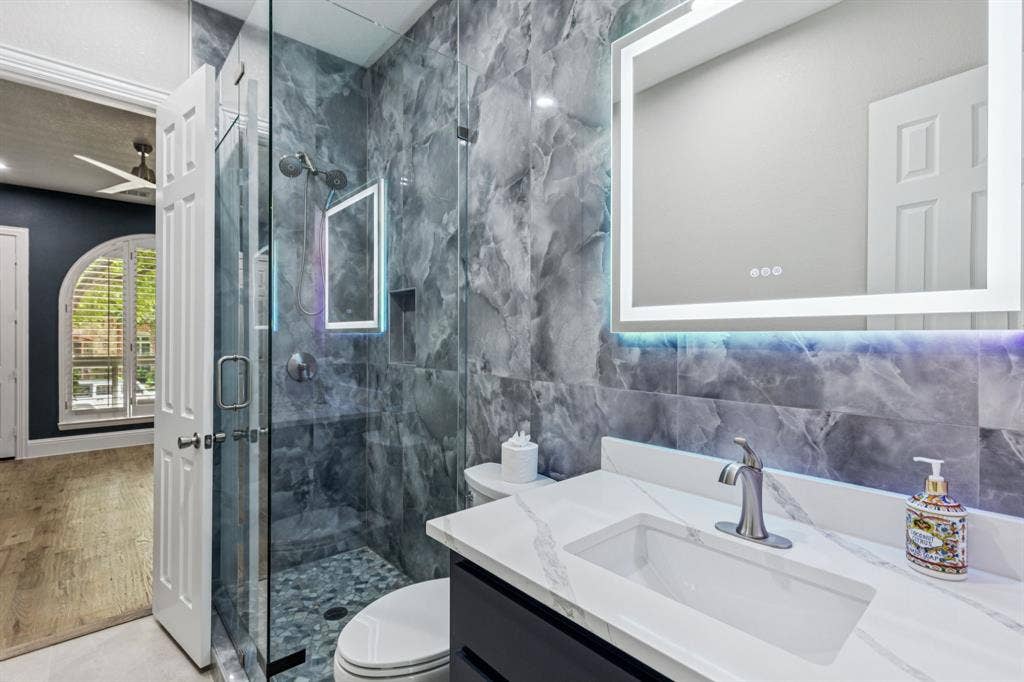15456 Mountain View Lane, Frisco, TX 75035 Glass-enclosed shower with pebble flooring, integrated wall niche, and dual shower heads