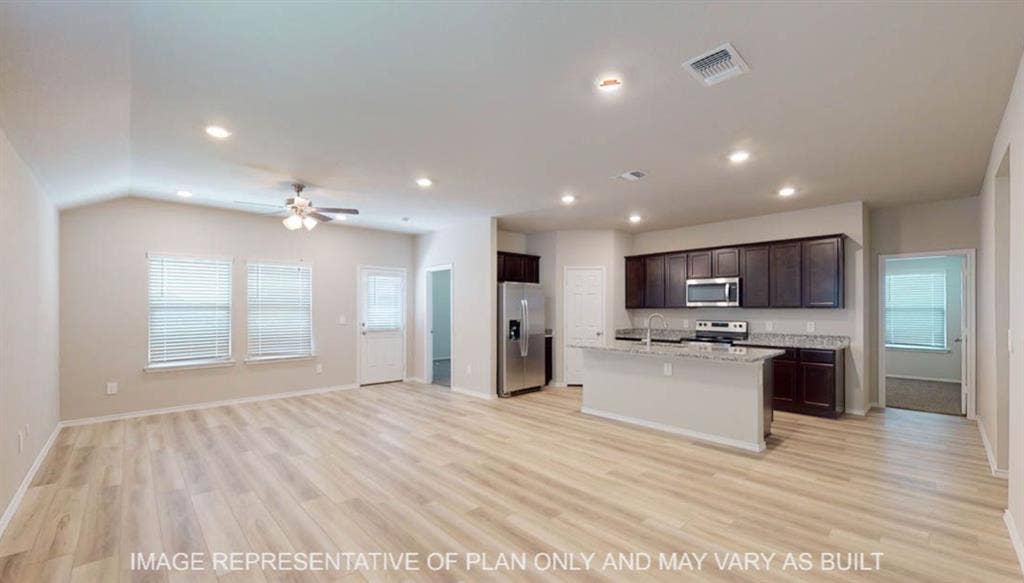 3112 Cyprian Road, Lorena, TX 76655 Spacious open-concept living area featuring wood-finish flooring, vaulted ceilings, and recessed lighting