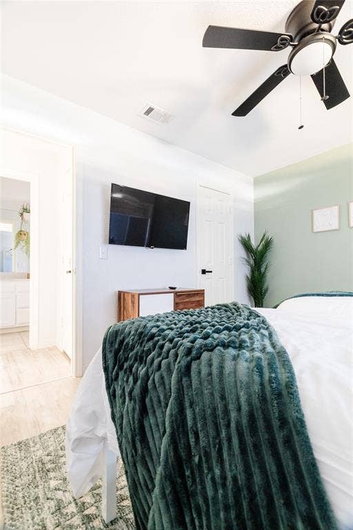 3612 Tumbril Lane, Plano, TX 75023 Ceiling fan with integrated lighting, wall-mounted television, wood-finish flooring, light-toned walls, and a door with matte black hardware