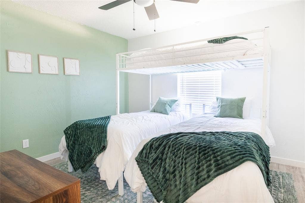 3612 Tumbril Lane, Plano, TX 75023 Light green accent wall, window with blinds, wood-finish flooring, and a ceiling fan