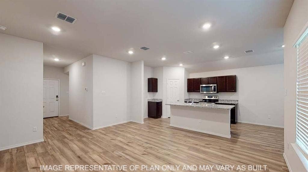 10428 Neptune Court, Waco, TX 76708 Open-concept living space with wood-finish flooring, recessed lighting, and a kitchen island featuring a light-toned countertop