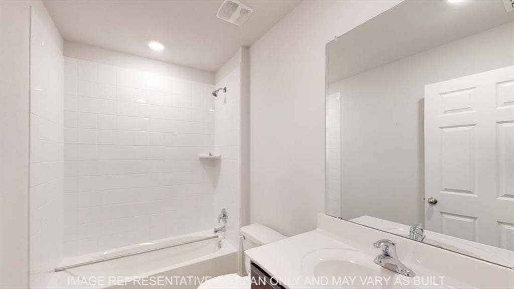 10428 Neptune Court, Waco, TX 76708 White subway tile shower surround with a built-in shelf, bathtub with chrome fixtures, single vanity with an integrated sink, and an expansive wall-mounted mirror