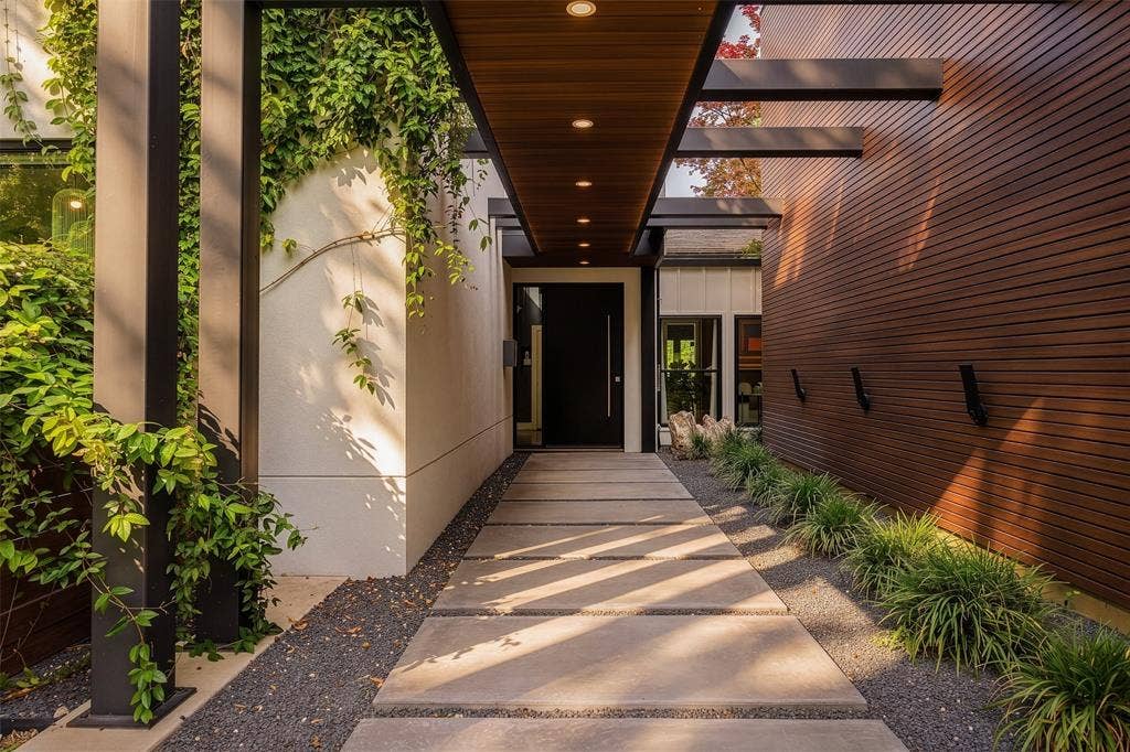 9863 Elmcrest Drive, Dallas, TX 75238 Beautiful entryway featuring a wood-finish ceiling with thoughtful lighting, a wood-paneled wall, and a concrete paver walkway.