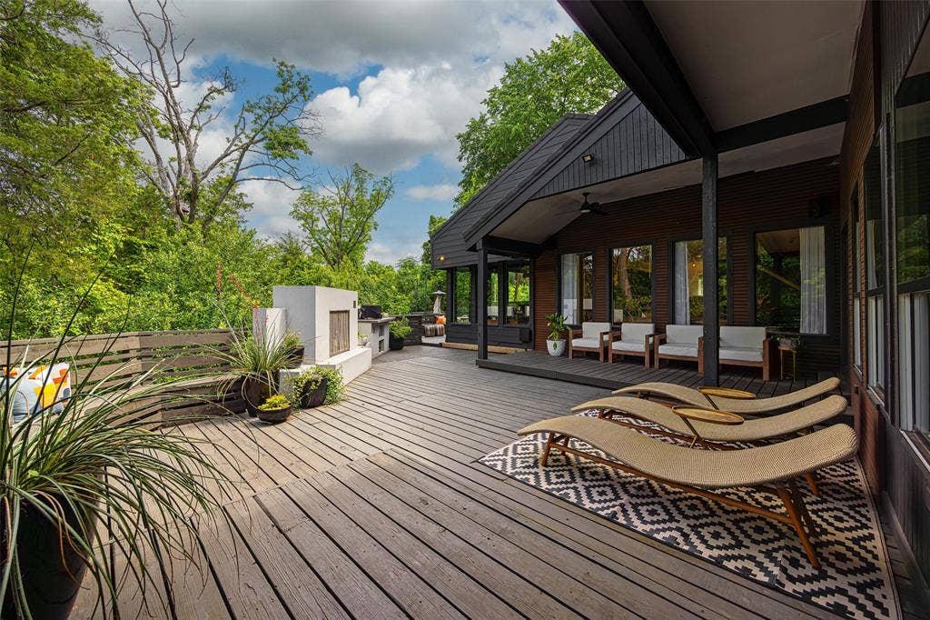 9863 Elmcrest Drive, Dallas, TX 75238 Expansive wood-plank deck with bench seating and covered porch.