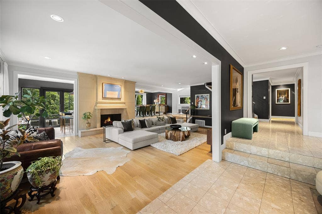 9863 Elmcrest Drive, Dallas, TX 75238 From foyer, view of sunken living room, wet bar and dining room with tree views, and oversized hallway leading to a downstairs guest bedroom, second floor staircase and kitchen.
