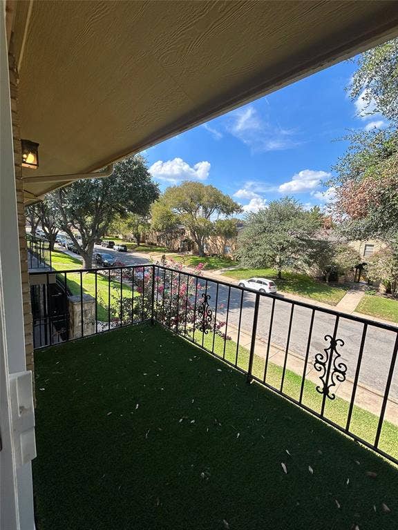 5826 Sandhurst Lane, #C, Dallas, TX 75206 Balcony with decorative iron railing, artificial turf flooring, and an overhead light fixture