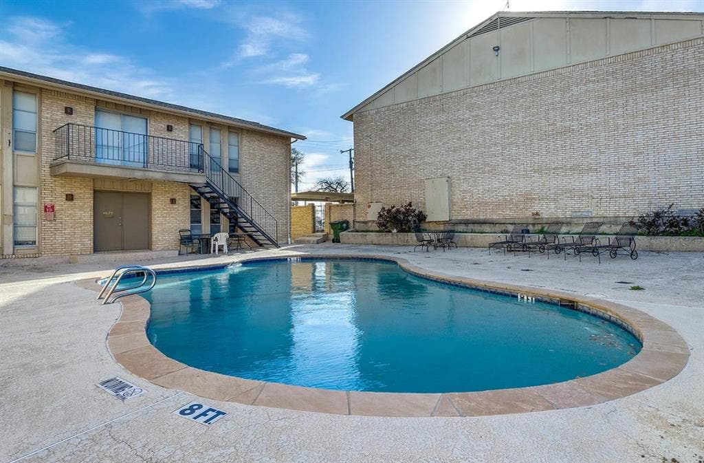 5826 Sandhurst Lane, #C, Dallas, TX 75206 Shaped swimming pool with concrete decking, surrounded by brick-clad buildings