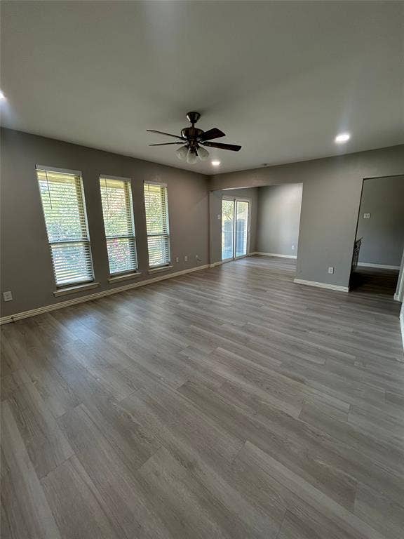 5826 Sandhurst Lane, #C, Dallas, TX 75206 Spacious room featuring wood-finish flooring, three large windows with blinds, recessed lighting, and a ceiling fan