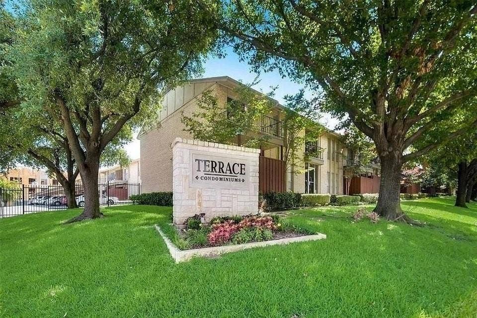 5826 Sandhurst Lane, #C, Dallas, TX 75206 Landscaped entrance featuring a stone monument sign, mature trees, and manicured green spaces