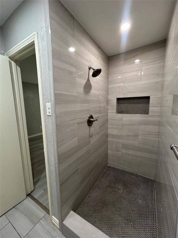 5826 Sandhurst Lane, #C, Dallas, TX 75206 Walk-in shower with large format tile walls, mosaic tile floor, and a built-in shower niche