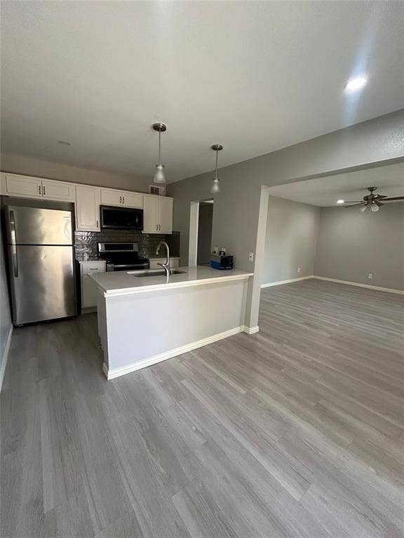 5826 Sandhurst Lane, #C, Dallas, TX 75206 Kitchen featuring stainless steel appliances, pendant lighting, and white cabinetry