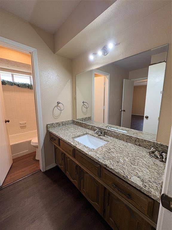 1025 Cloverdale Lane, DeSoto, TX 75115 Extended vanity with a rectangular undermount sink, granite-style countertop, and wood-finish cabinetry