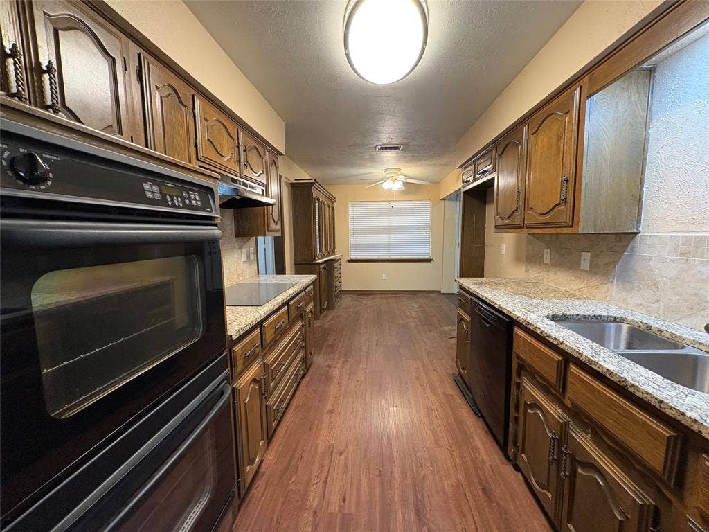 1025 Cloverdale Lane, DeSoto, TX 75115 Galley kitchen featuring wood cabinetry, integrated double oven, and a built-in cooktop