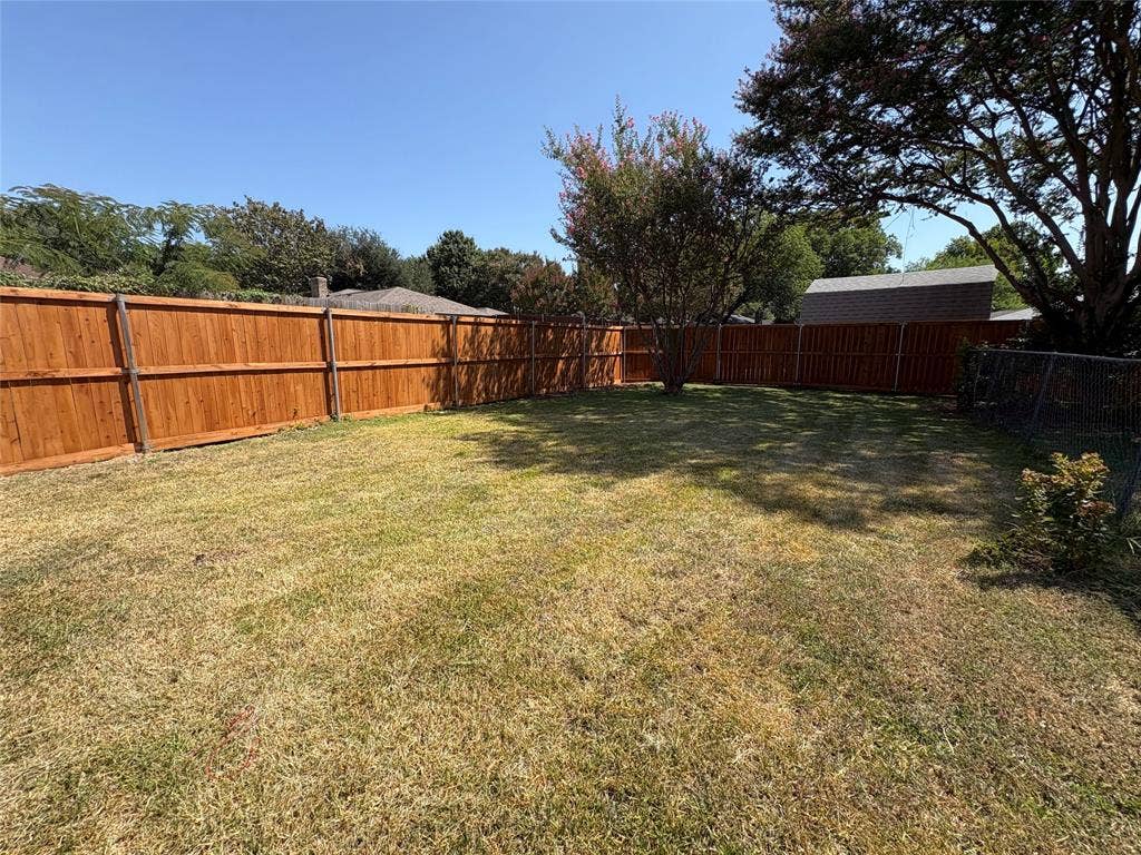 1025 Cloverdale Lane, DeSoto, TX 75115 Spacious backyard featuring wood fencing and established trees