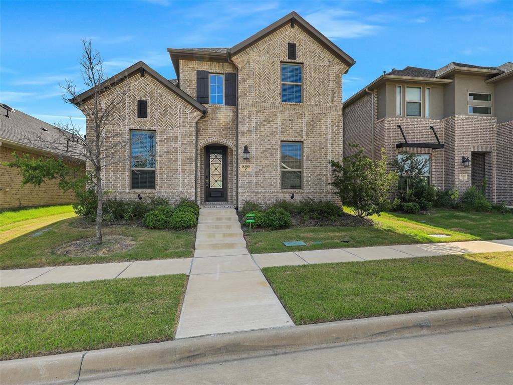 8305 Pine Island Way, McKinney, TX 75071 Two-story brick exterior with decorative window shutters and a gabled roofline