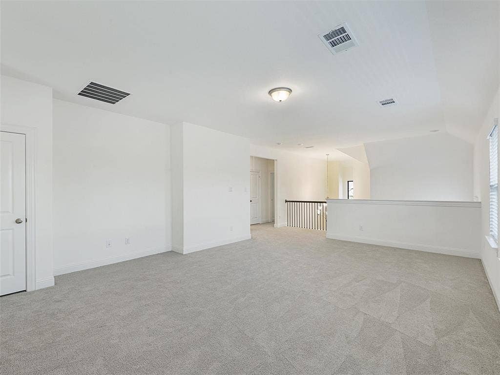 8305 Pine Island Way, McKinney, TX 75071 Spacious loft area with light gray carpeting, white walls, and a semi-flush ceiling light fixture