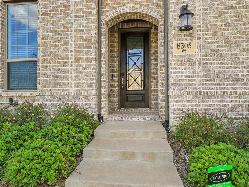 8305 Pine Island Way, McKinney, TX 75071 Welcoming entry featuring a brick exterior with arched doorway, sidelite detailing, and brass hardware