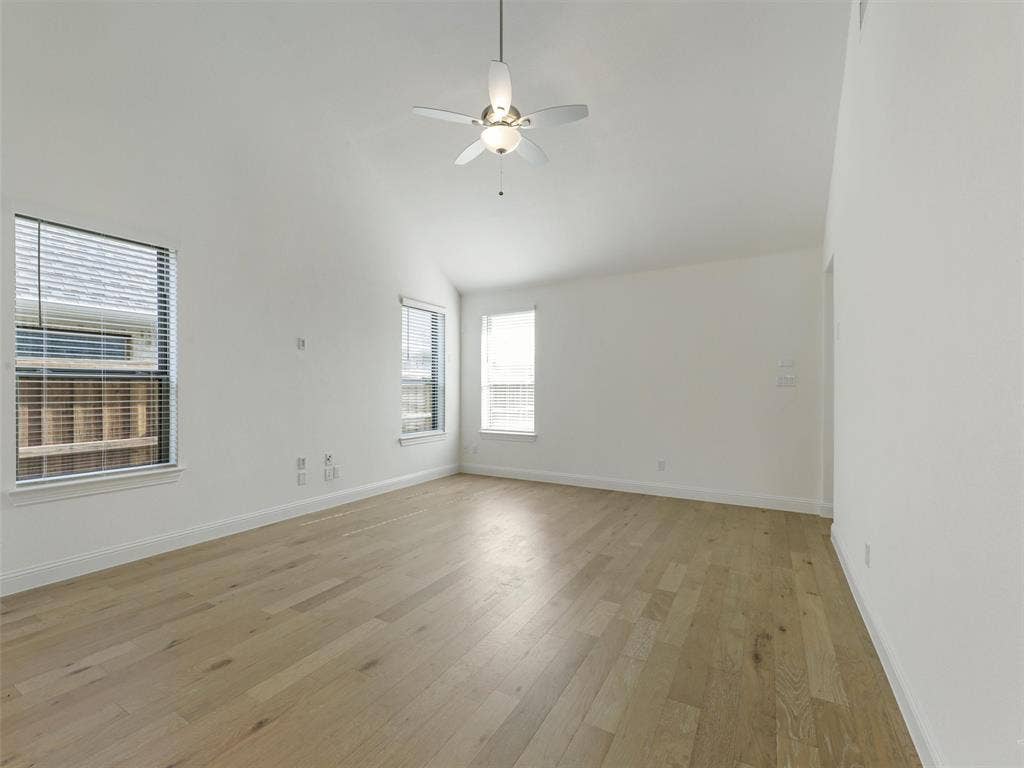 8305 Pine Island Way, McKinney, TX 75071 Vaulted ceiling, ceiling fan, wood-finish flooring, multiple windows with blinds, white walls