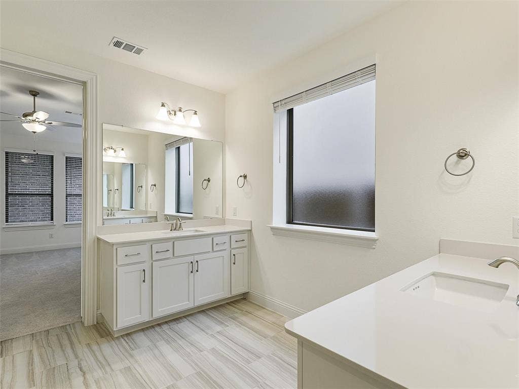 8305 Pine Island Way, McKinney, TX 75071 Dual vanity with white cabinetry and integrated sinks