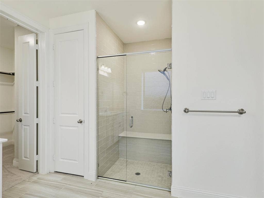 8305 Pine Island Way, McKinney, TX 75071 Glass-enclosed shower with a built-in bench, tiled shower walls, and a recessed window