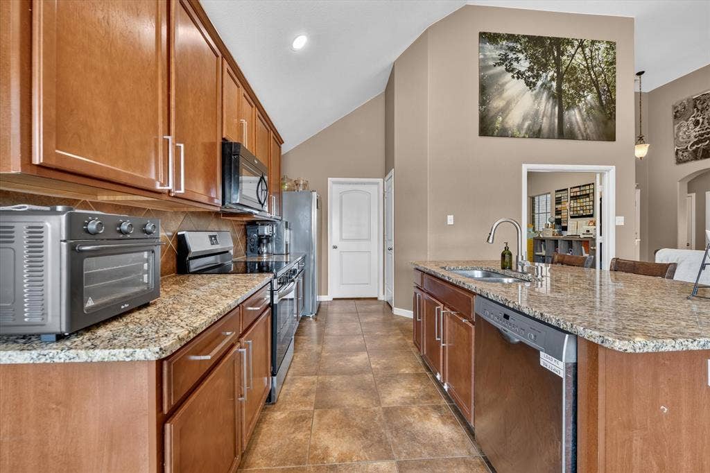 424 Foxcraft Drive, Fort Worth, TX 76131 Kitchen featuring abundant wood cabinetry, an expansive island with a sink, a dishwasher, and granite countertops