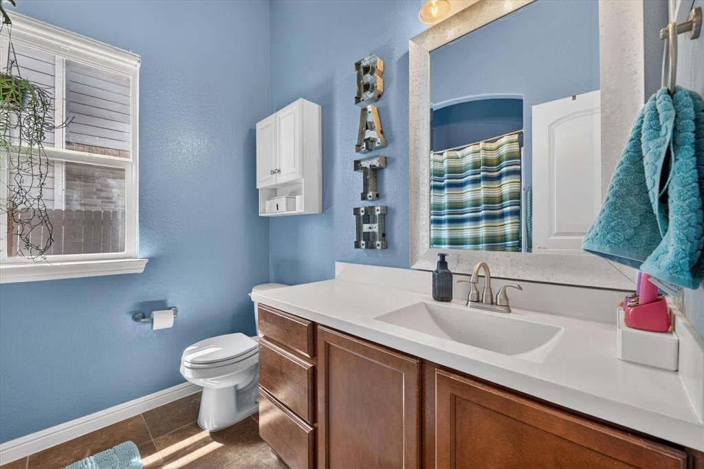 424 Foxcraft Drive, Fort Worth, TX 76131 Built-in vanity with a single basin sink, white countertop, and wood-finish cabinetry