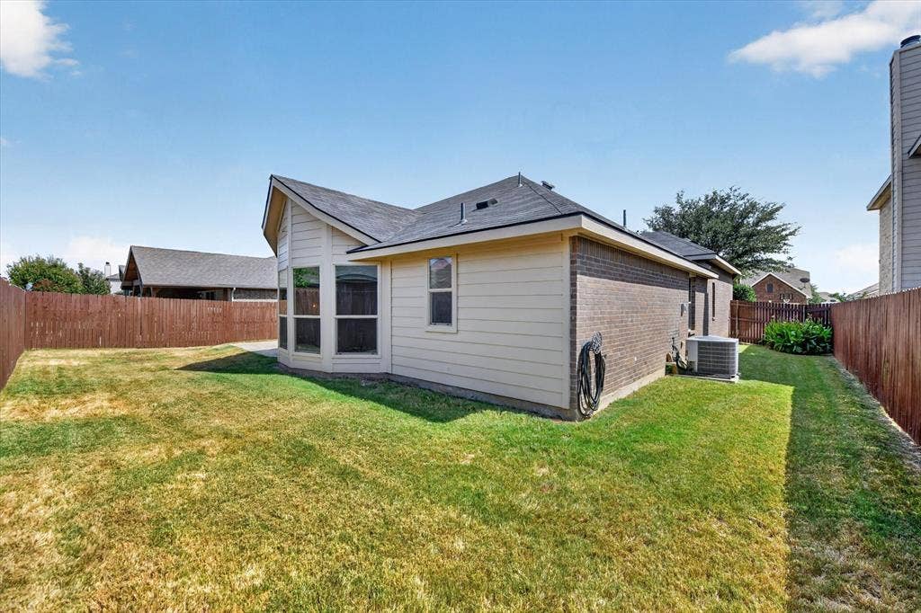 424 Foxcraft Drive, Fort Worth, TX 76131 Expansive fenced backyard featuring a brick and siding exterior and bay windows