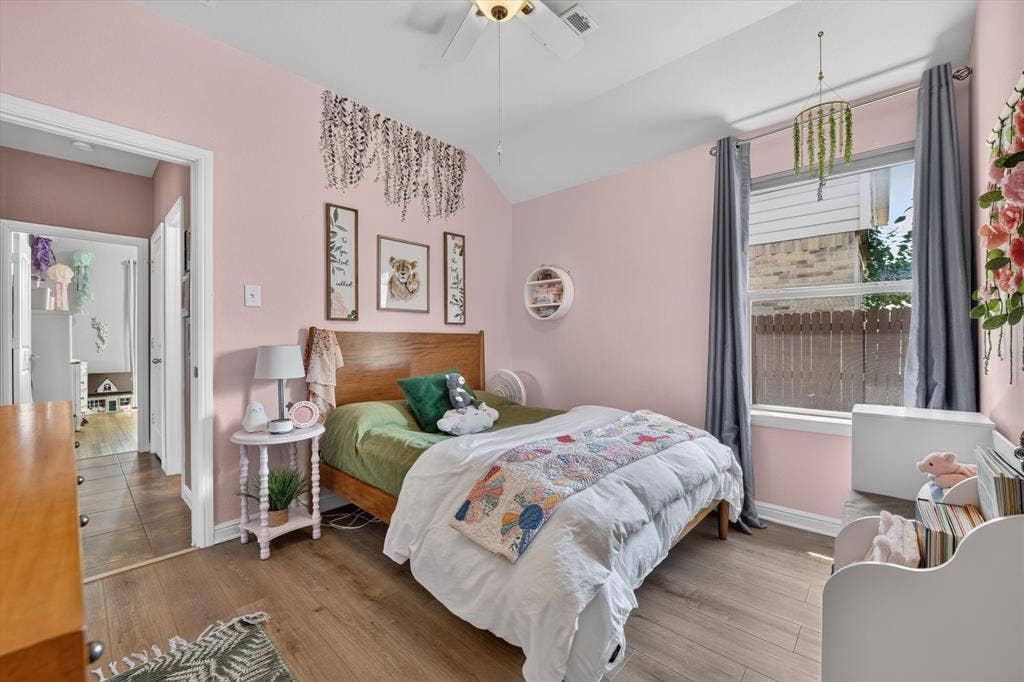 424 Foxcraft Drive, Fort Worth, TX 76131 Vaulted ceiling with a ceiling fan, wood-finish flooring, and a window with drapery